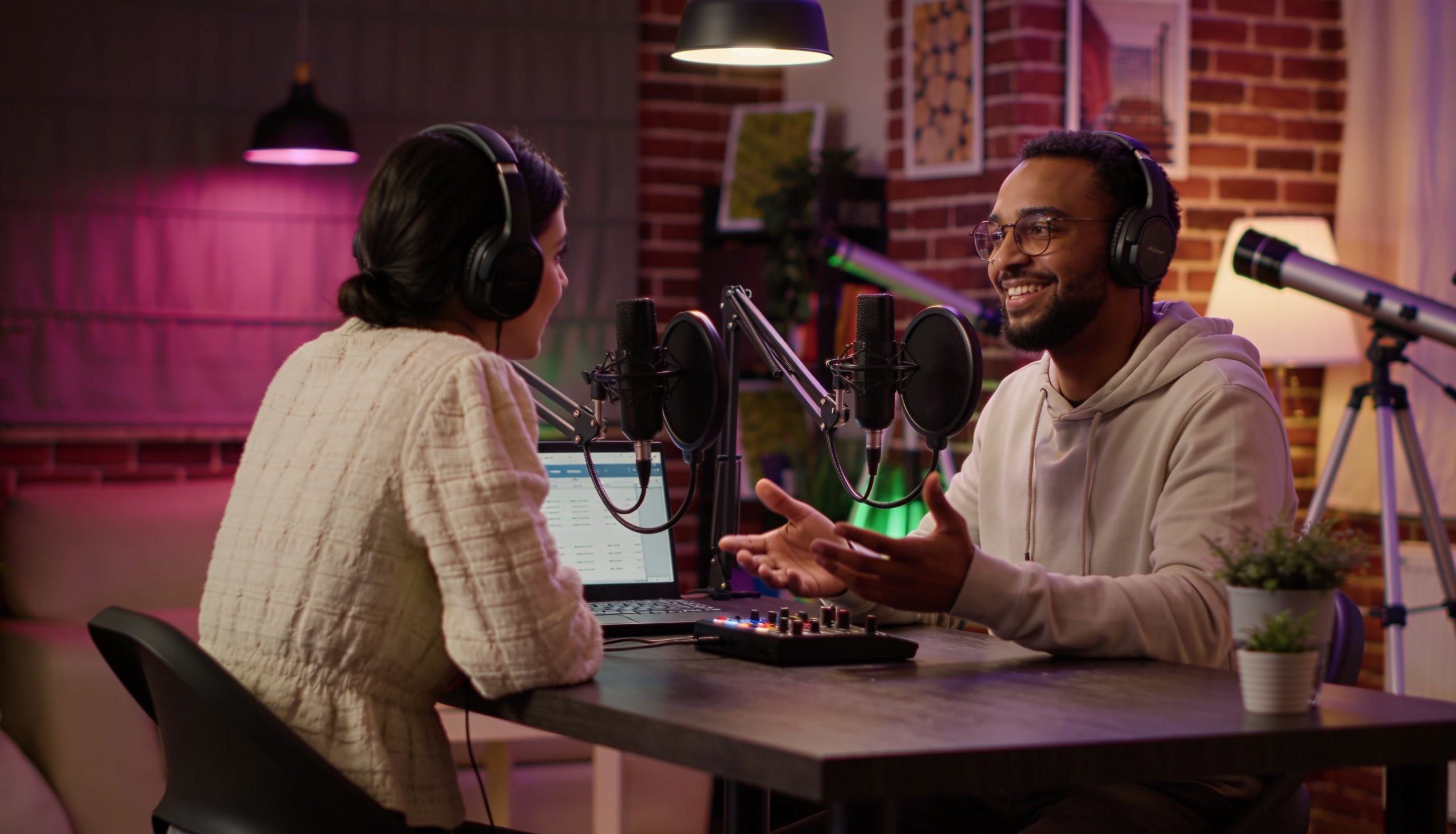 Two Arab podcast hosts recording in a media studio